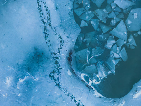 Panoramic aerial view of a frozen lake with animal tracks and cracked ice. Animal tracks on the...