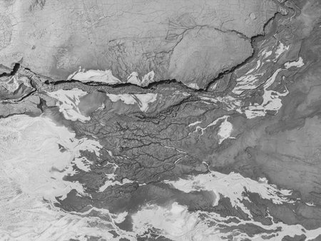 The structure of cracked wet earth at the bottom of the lake, creating irregular patterns,...