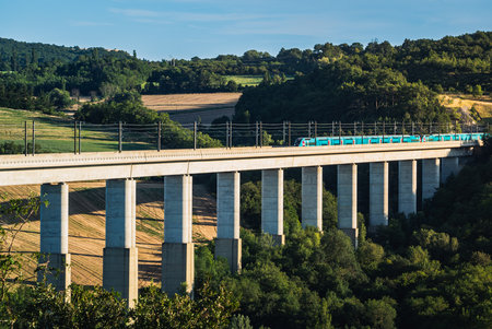 Grane, France - August 2023: Panoramic view on passenger train TGV crossing the railway flyover. Overlooking the surrounding mountains in southern Franceのeditorial素材
