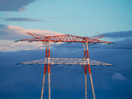High Voltage Electric Transmission Tower Energy Pylon with blue sky and clouds