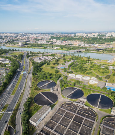 Eco-friendly aerial view of wastewater treatment plant near Lyon, France, with urban skyline â sustainable water management and environmental protection conceptの写真素材