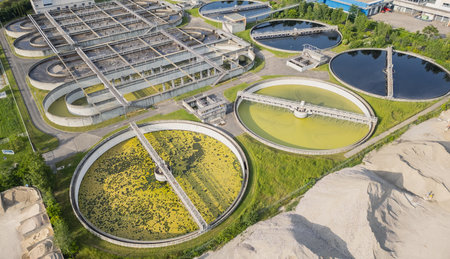 Eco-friendly aerial view of wastewater treatment plant near Lyon, France, with urban skyline...