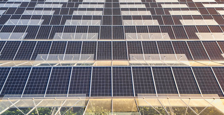 Sustainable greenhouse with rooftop solar panels bathed in morning sunlight for eco-friendly...