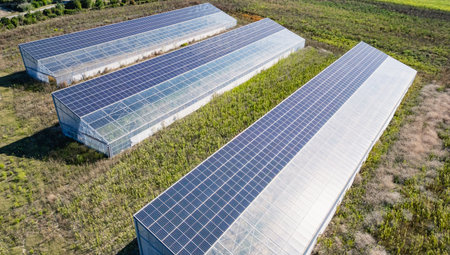 Aerial view of modern solar greenhouses with photovoltaic panels on roofs, renewable energy and...