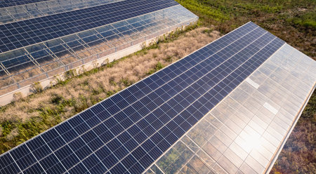 Aerial view of modern solar greenhouses with photovoltaic panels on roofs, renewable energy and...