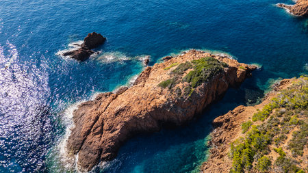 Spectacular panoramic aerial view of Esterel Mountains red cliffs above the Mediterranean Sea, French Riviera, Southern France, dramatic coastline, rugged cliffs, scenic seascapeの写真素材