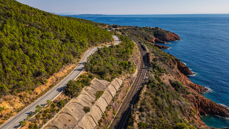 Panoramic aerial view of Esterel Mountains coastline with winding coastal road and railway tracks above the Mediterranean Sea, French Riviera, Southern France, scenic cliffs and ocの写真素材