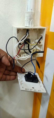 Close up of an electrician's hand holding a power strip.の写真素材