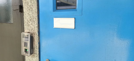 Blue metal door of an old train station with a sign on itの写真素材