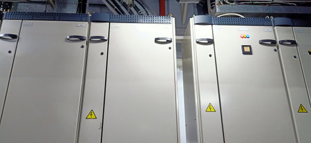A row of stainless steel cabinets with yellow warning signs in a factoryの写真素材