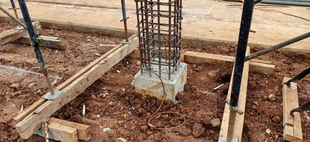 Construction site with scaffolding on the ground and concrete pillars for the foundationの写真素材