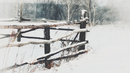 wooden fence in the snow in the winter season in the villageの写真素材