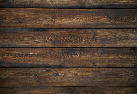 A background of dark wood planks tightly adjacent to each other. Wooden boards with a clearly...