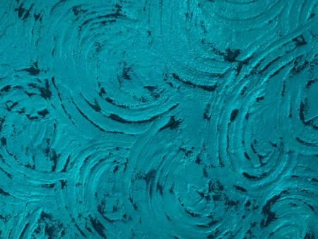 Decorative texture of a turquoise wall with a rounded pattern. Wall with decorative plaster. Pattern made by the fingers.の写真素材