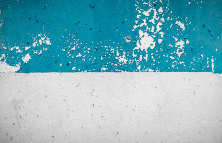 Scratched wall texture. White-blue wall. Old rough painted surface. Half blue and half white aged wall with scratches. Design element of abstract construction background. Foreground.の写真素材