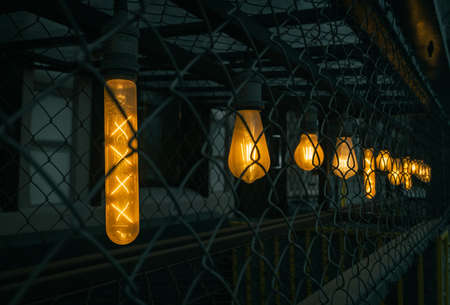 Lamps of various elongated and round shapes shine with yellow light behind the grille. The filament...