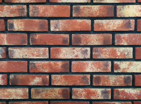 An old beautiful textured brick wall after restoration. Dark concrete between bricks