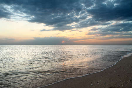 Sunset view from the sandy beach by the sea.の写真素材