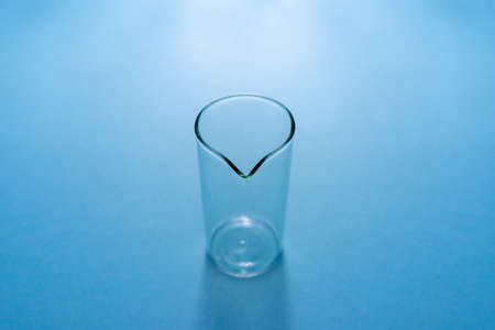 Empty chemical beaker on a blue background.の写真素材