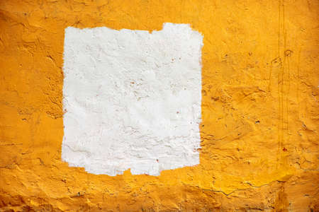 The texture of a bright orange concrete wall with white painted space. Place on a textured concrete wall for text.の写真素材