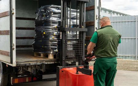 Loading packed high pressure hydraulic hoses into a truck using a forklift. The operator controls the loading.の写真素材