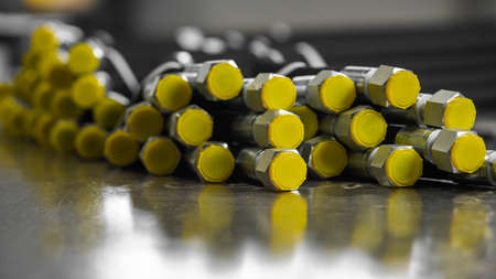 A bundle of new high-pressure hydraulic hoses are lying on a metal table. Hydraulic hoses with...