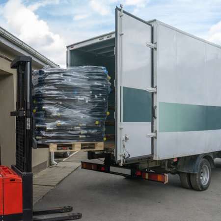 Loading the product into a truck using a forklift during the day. Transportation of goods.の写真素材