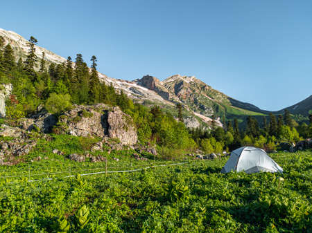 A tent in the mountains behind a protective fence. Tent in a camp protected from wild animals.の写真素材