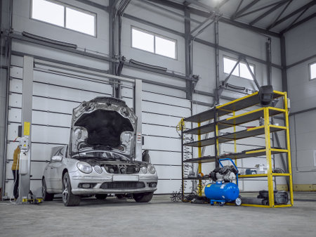 A car with a raised hood in a car service.の写真素材