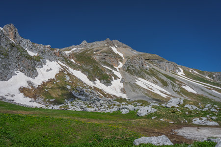 Sheer cliffs in spring with not completely melted glaciers. mountain landscapes.の写真素材