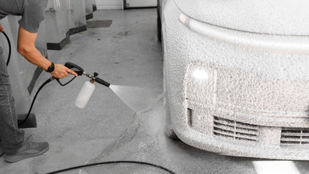 Applying foam to a car at a car wash. Spraying foam onto a car with a spray bottle. Detergentの写真素材