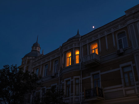 Beautiful old building with a spire at night. Lights are on in the windows of the beautiful buildingの写真素材