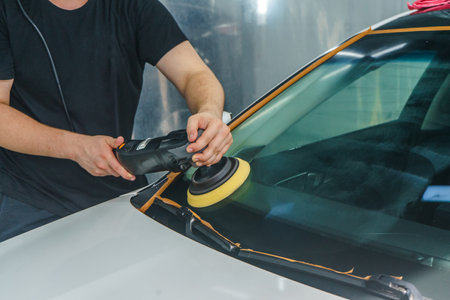 Taking care of the car's appearance. The master polishes the windshield of a car. Detailingの写真素材