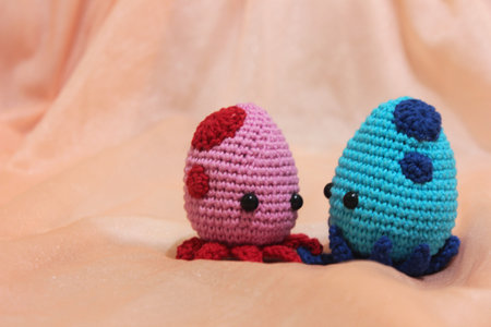 Cute couple of octopuses playing together. The colors are red and blue, made with cotton yarn, using the crochet technique. Amigurumi Crochet.の写真素材