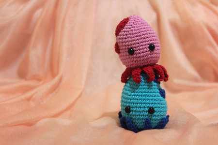 Cute couple of octopuses playing together. The colors are red and blue, made with cotton yarn, using the crochet technique. Amigurumi Crochet.の写真素材