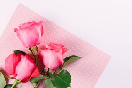 Bouquet of three pink roses on a light colored background. Greeting concept. Flat lay styleの写真素材