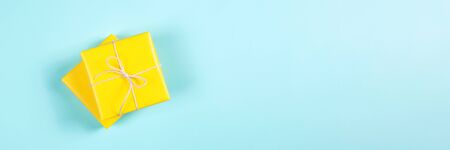 Two yellow gift boxes on blue background. Banner for websiteの写真素材