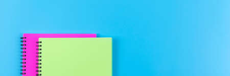 Two spiral notebooks on blue background. Top view. Banner for website.の写真素材