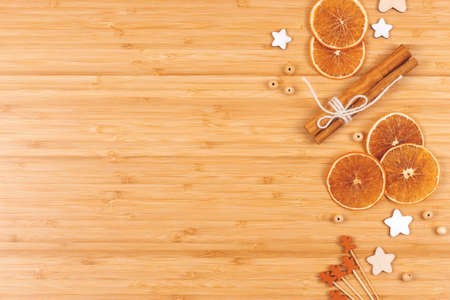 Bakery background made with dried orange slices, decorations and cinnamon sticks on wooden table....