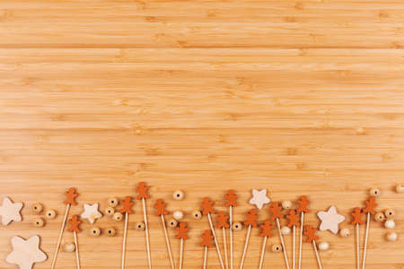 Wooden background with decorative gingerbread men, stars and beads on table. Holiday baking concept....