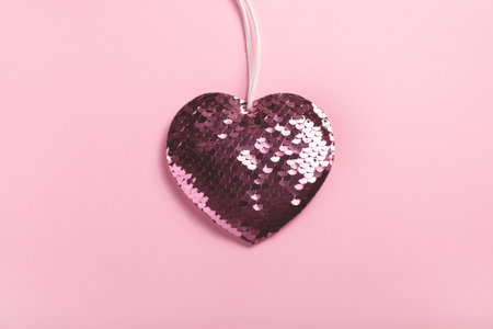 Sparkle sequin heart on pink background. Top view, copy space.の写真素材