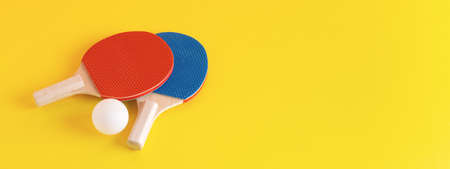 Table tennis kit on yellow background. Red and blue   rackets and white ball. 16:6 web banner.の写真素材