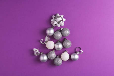 Christmas tree made of metallic baubles on purple background. Top view. Christmas and New Year concept.の写真素材