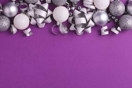 Holiday background with grey and white metallic decorations on purple. Copy space. Christmas and New Year.の写真素材