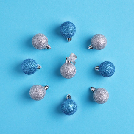 Blue and silver Christmas balls on pastel blue background. Square Xmas and New Year greeting card.の写真素材