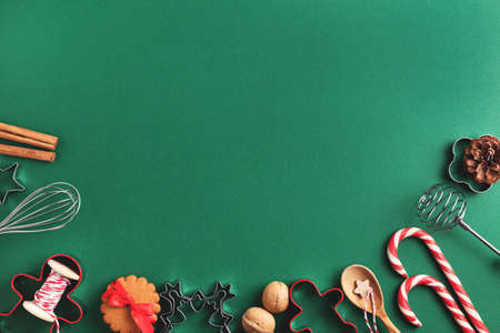 Green Christmas baking flat lay with ginger cookies, candy canes, kitchen utensil and winter decoration. Xmas and New Year holiday frame.の写真素材