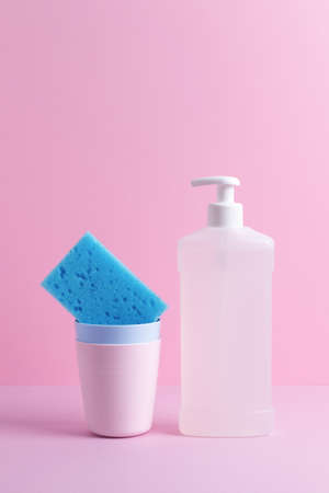 Dishwashing composition with cleaning supplies on pink background with empty space. Front view.の写真素材