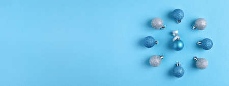 Christmas composition with blue and silver festive baubles arranged on pastel blue background. Winter banner for website.の写真素材