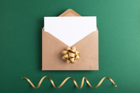 Green invitation or greeting background with clean paper card in festive envelope. Place for text.の写真素材