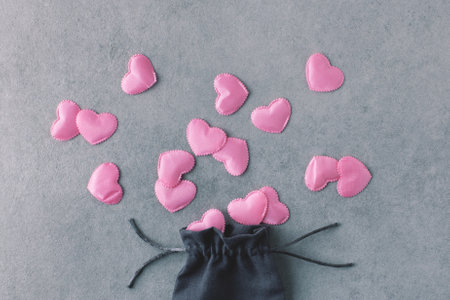 Romantic flatlay made of silk pink hearts and tissue bag on grey stone background. Love, Valentines day, decorative concept.の写真素材